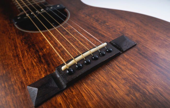 Acoustic guitar bridge of a brown instrument