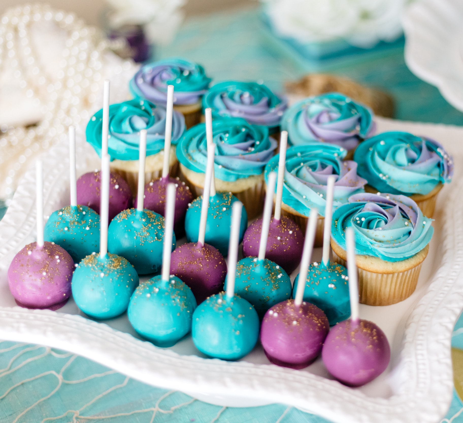 Image of colorful cake pops on platter with cupcakes