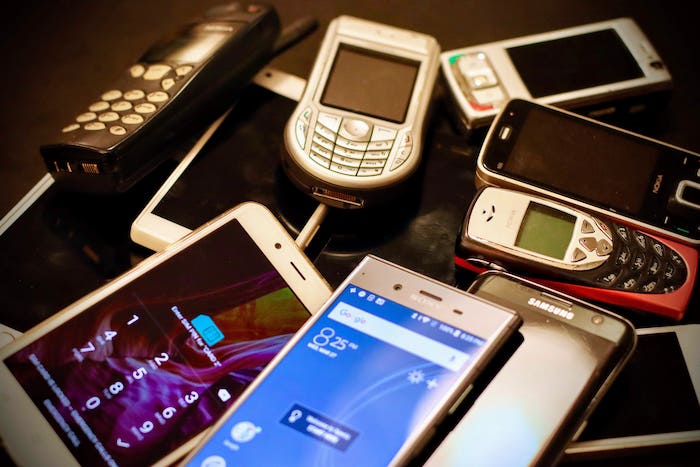 Une dizaine de portables de toutes les marques et de toutes les générations sont entassés les uns sur les autres, preuve de l'effet rebond de la production incessante de nouveaux appareils numériques.