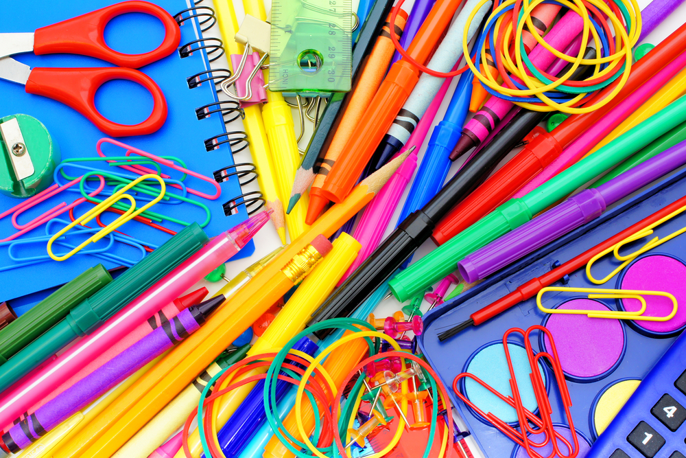 An assortment of brightly-colored pencils, pens, scissors, notebooks, rulers, paperclips, and many other school supplies