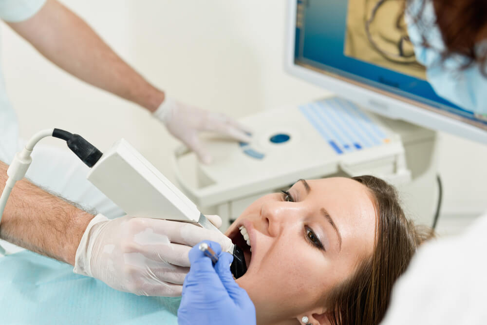 CEREC Verfahren: intraorale Kamera misst Zähne einer Patientin
