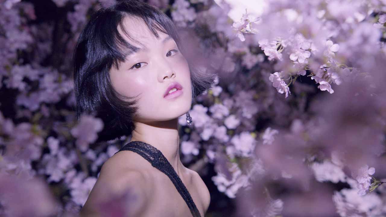Girl in cherry blossom forest at night