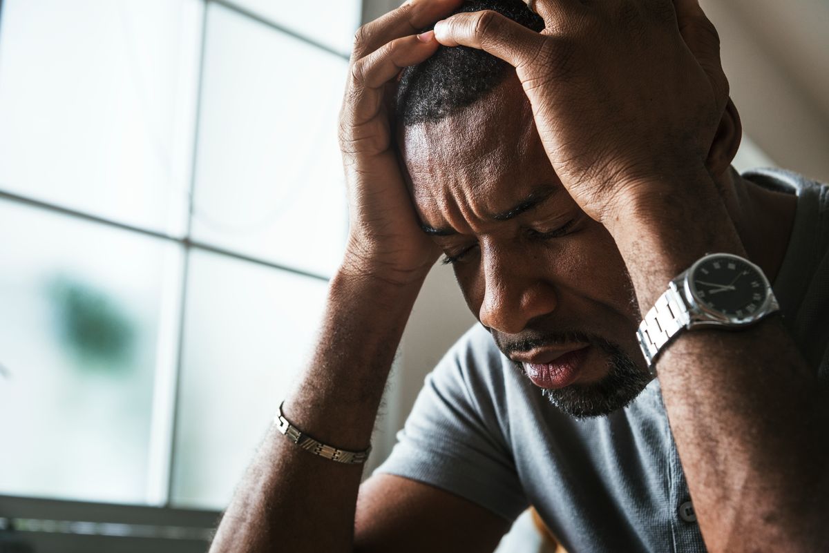 black man holding his head and is depressed for being addicted to blue xanax