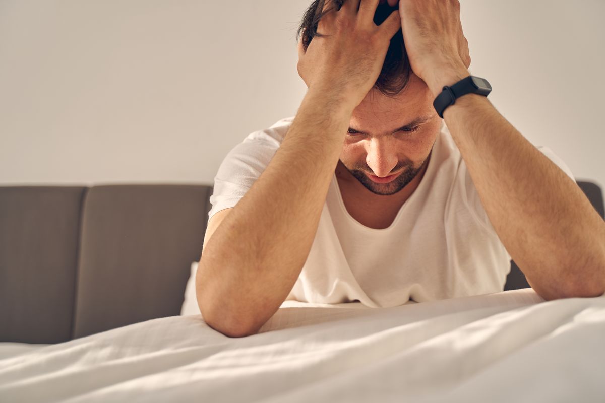 a man who is addicted into Gabapentin is holding her head while he is on bed