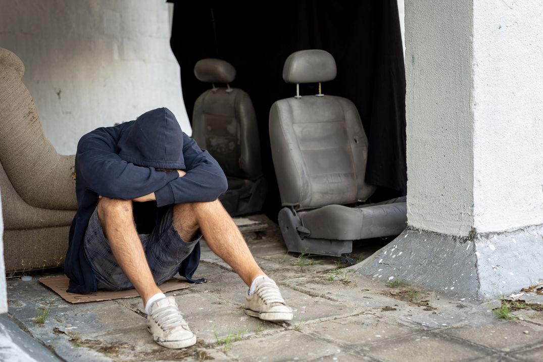 a man who is addicted in lsd and acid is seen here sitting on the floor while depressed