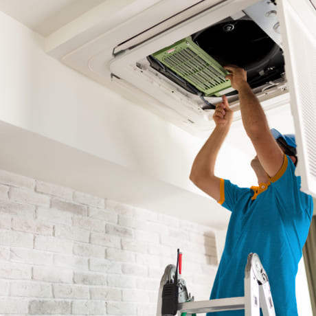 Technicien qui répare une climatisation