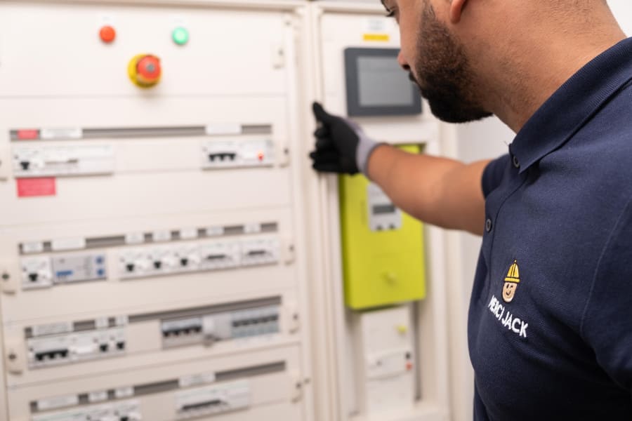 Technicien de Merci Jack qui vérifie un tableau électrique