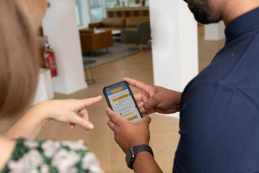 Technicien qui montre l'application Merci Jack à une cliente