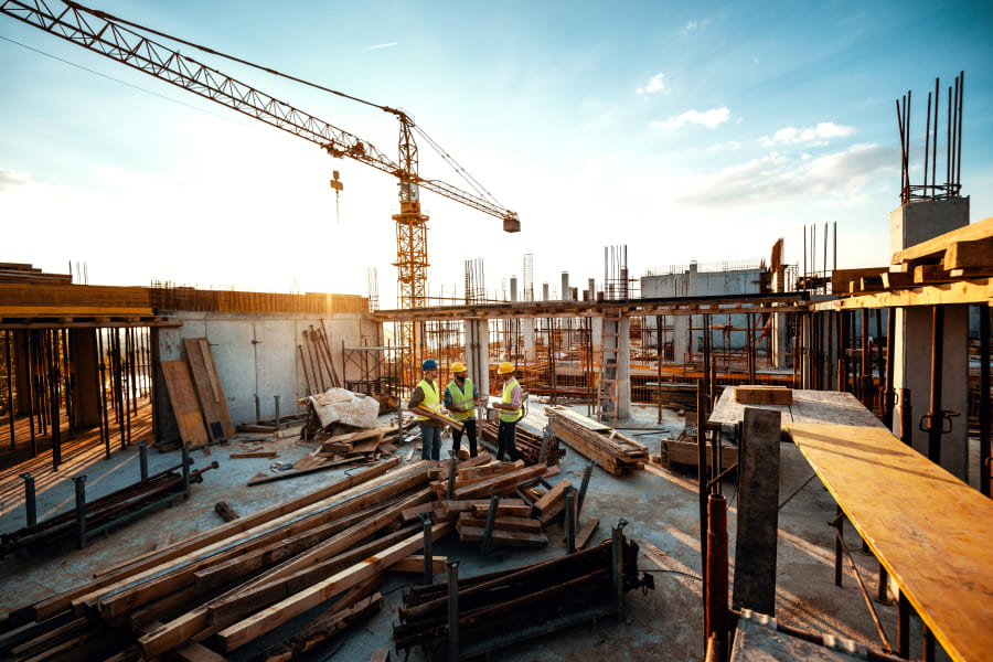 réunion de chantier avec trois artisans du bâtiment