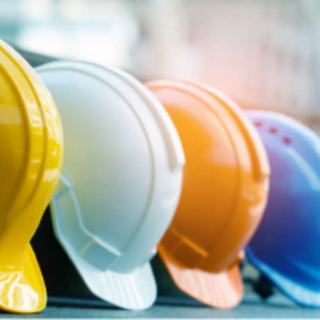 quatre casques de chantier de différentes couleurs