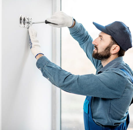 Technicien de maintenance qui installe des prises électriques