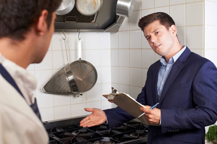 Inspecteur qui contrôle la conformité d'une cuisine professionnelle