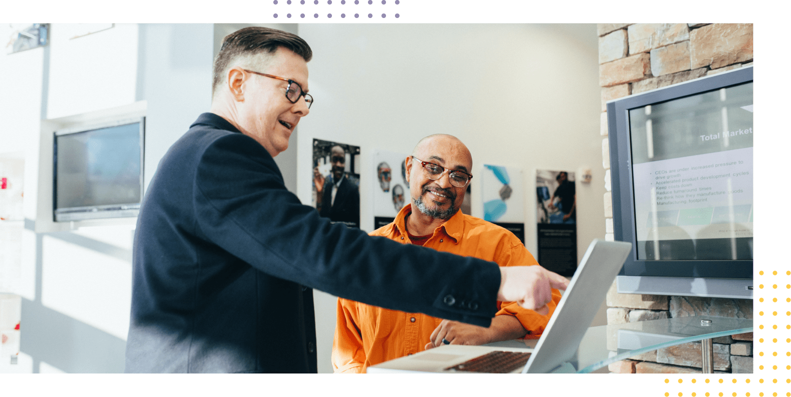 Picture of a businessman and business owner discussing about the features on a laptop