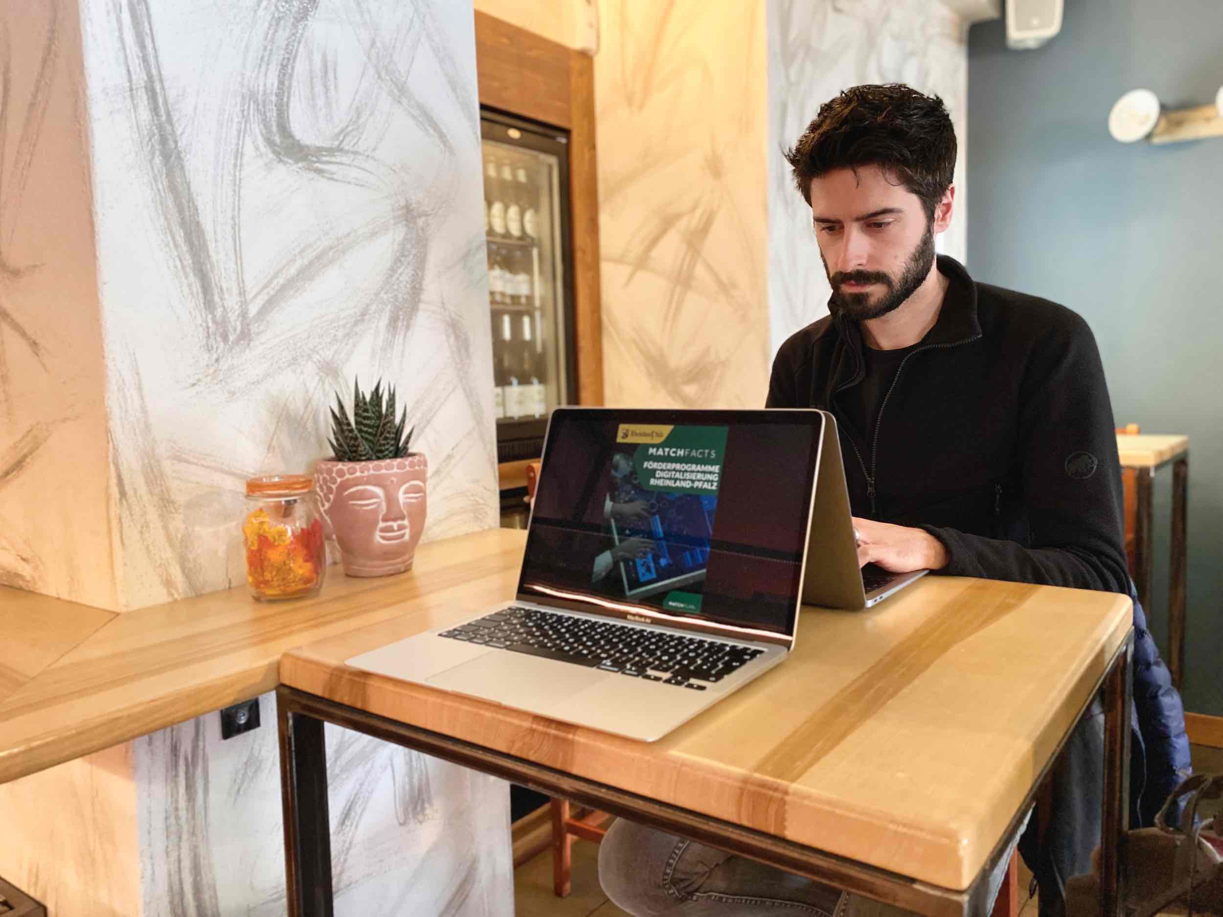 Jan bei der (papierlosen) Arbeit in einem Café