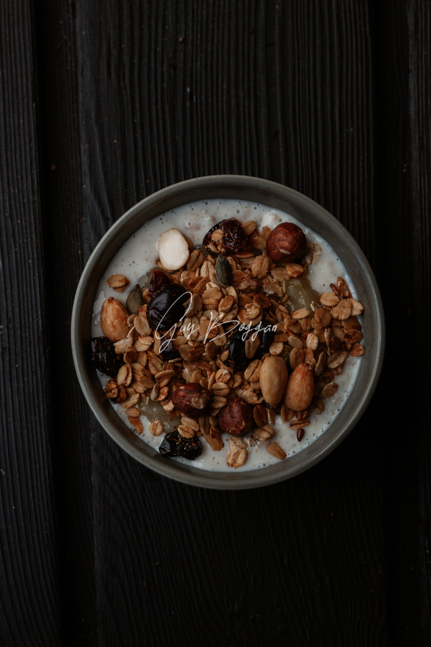 A top down shot of a bowl of porridge on a dark wood surface