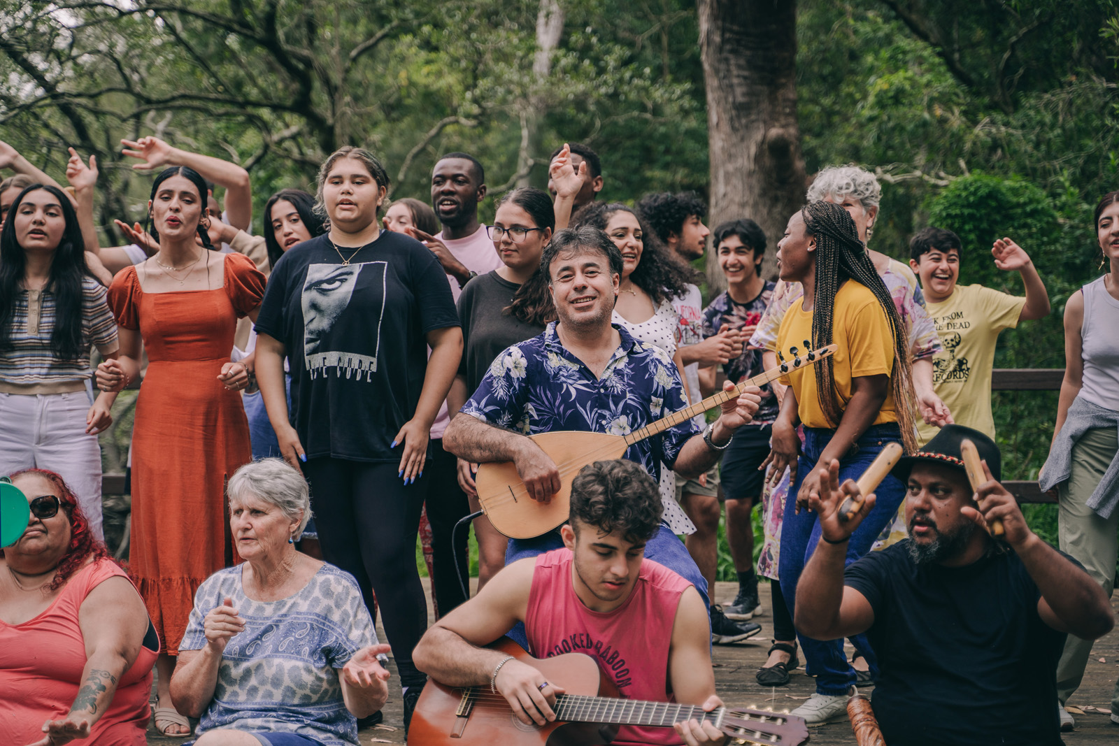 group of people singing together under some trees