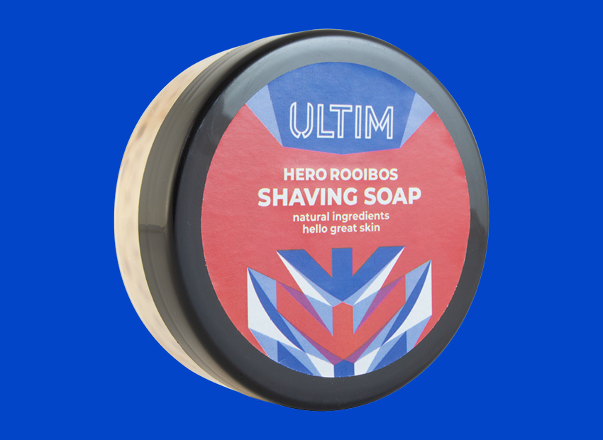 Packaging for ULTIM shaving soap. Geometric blue and white pattern on a red background.
