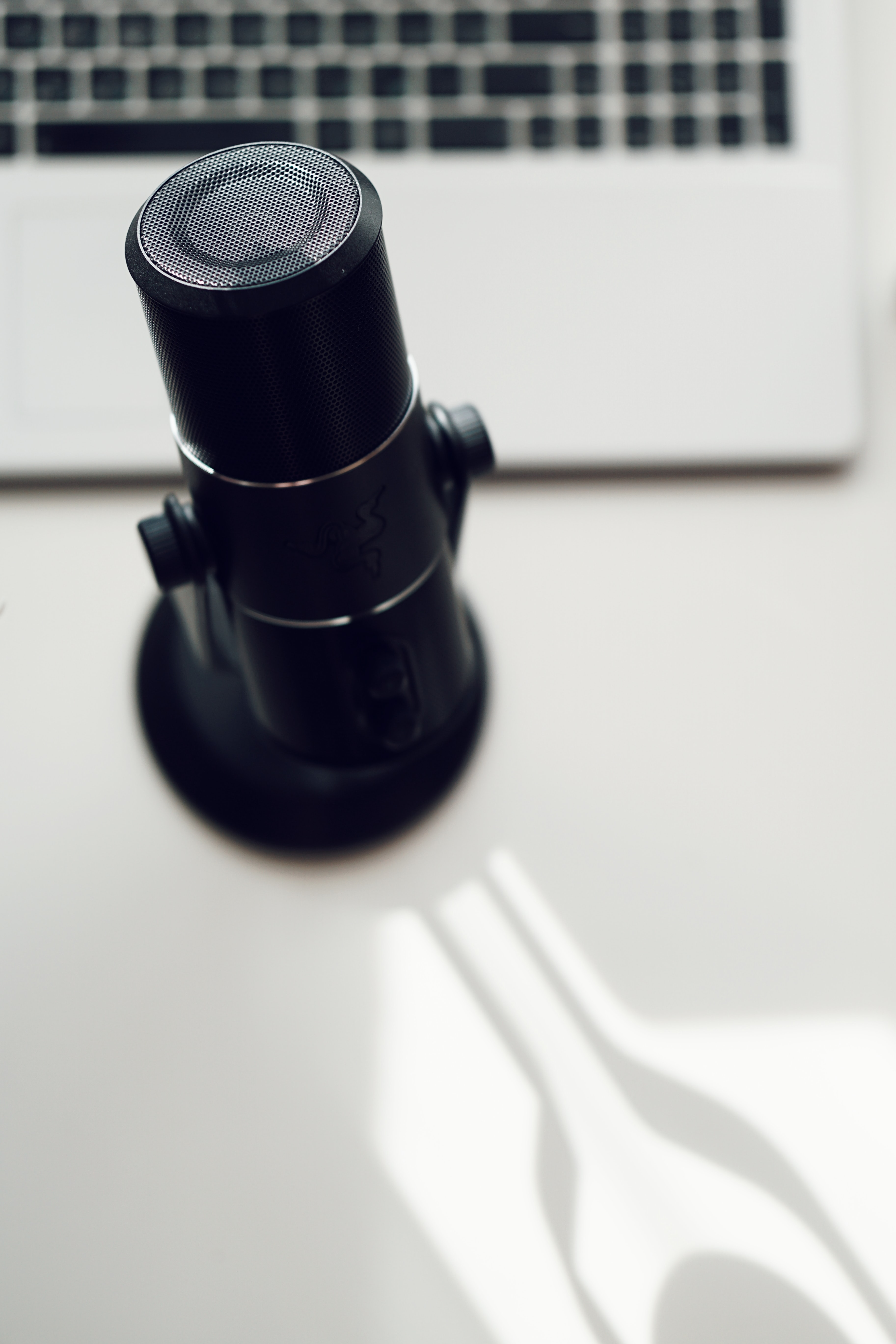 Microphone on a desktop next to a laptop