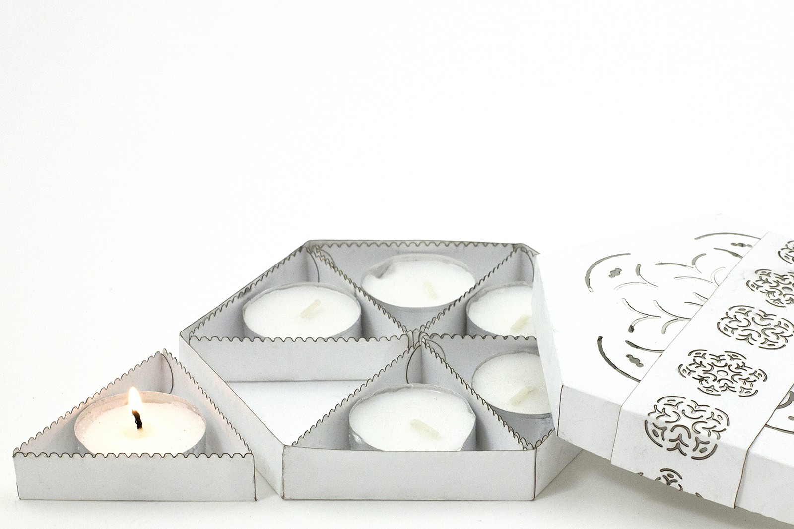 Six candle packaging, open, candle lit.