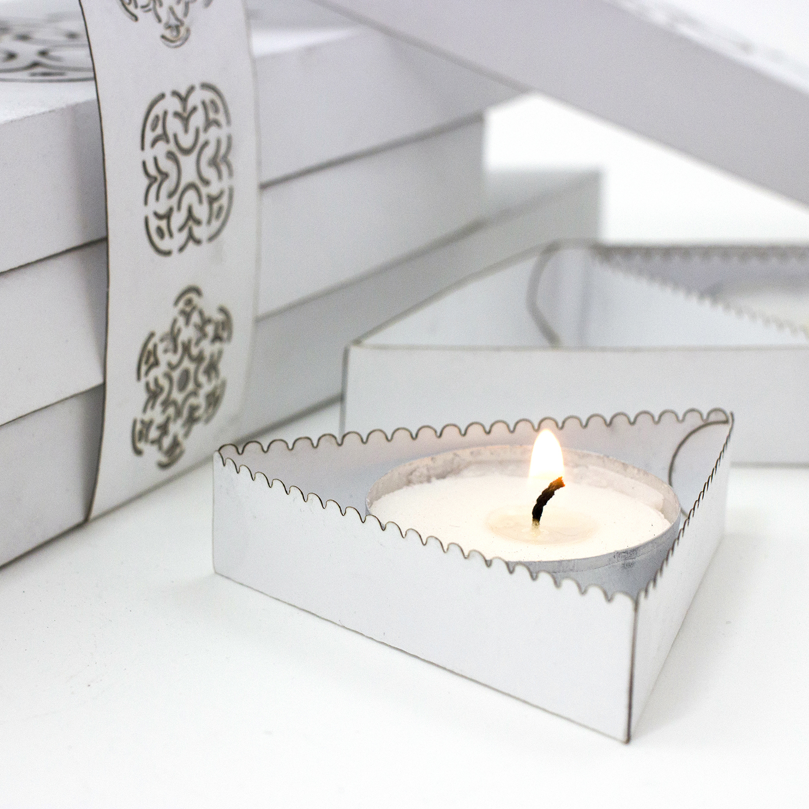 Lit candle in interior packaging, lights on.