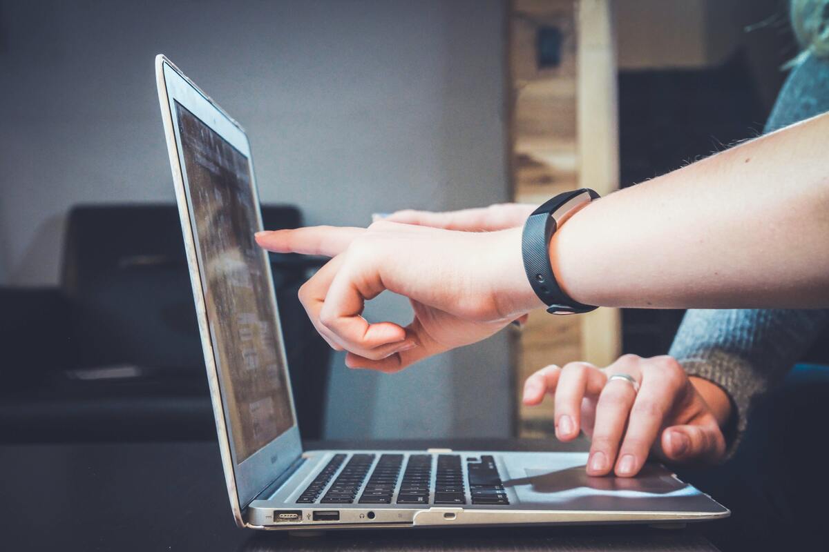 person-showing-something-on-open-laptop