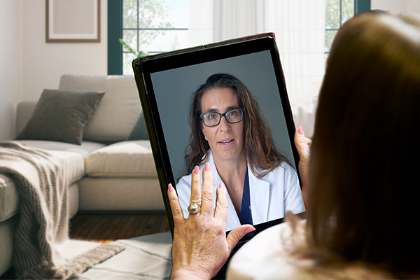 Woman uses large tablet to meet with a female healthcare provider.