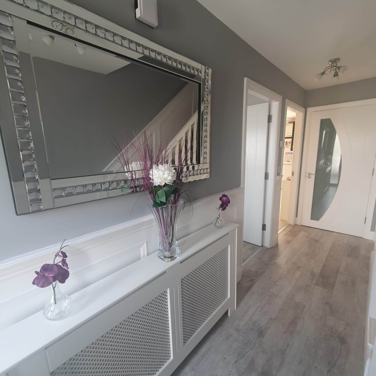 Image of hallway with radiator cover, panelling and white doors