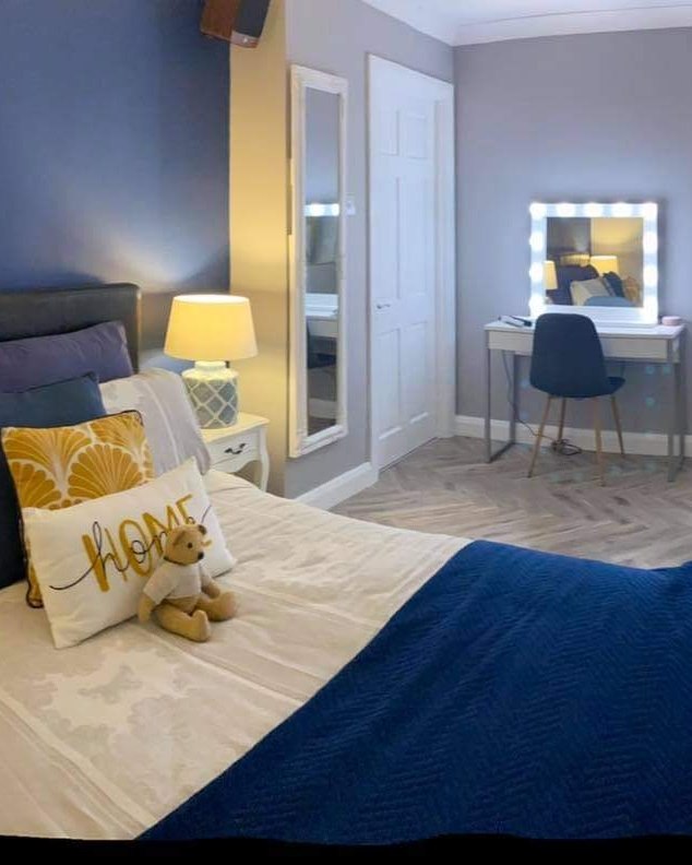 Image of bedroom with bed, lamp, dressing table and chair