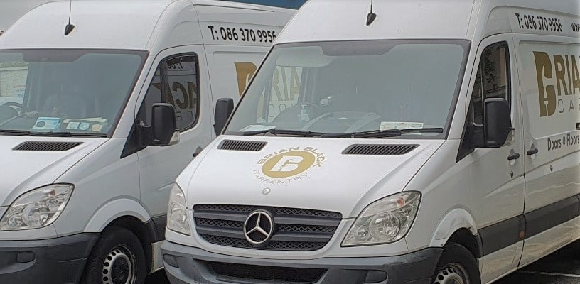 Image of two white vans with Brian Black Logo