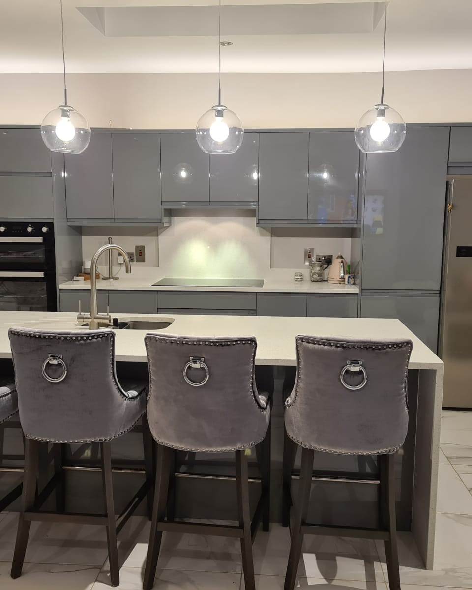 Image of kitchen with grey units and grey high chairs