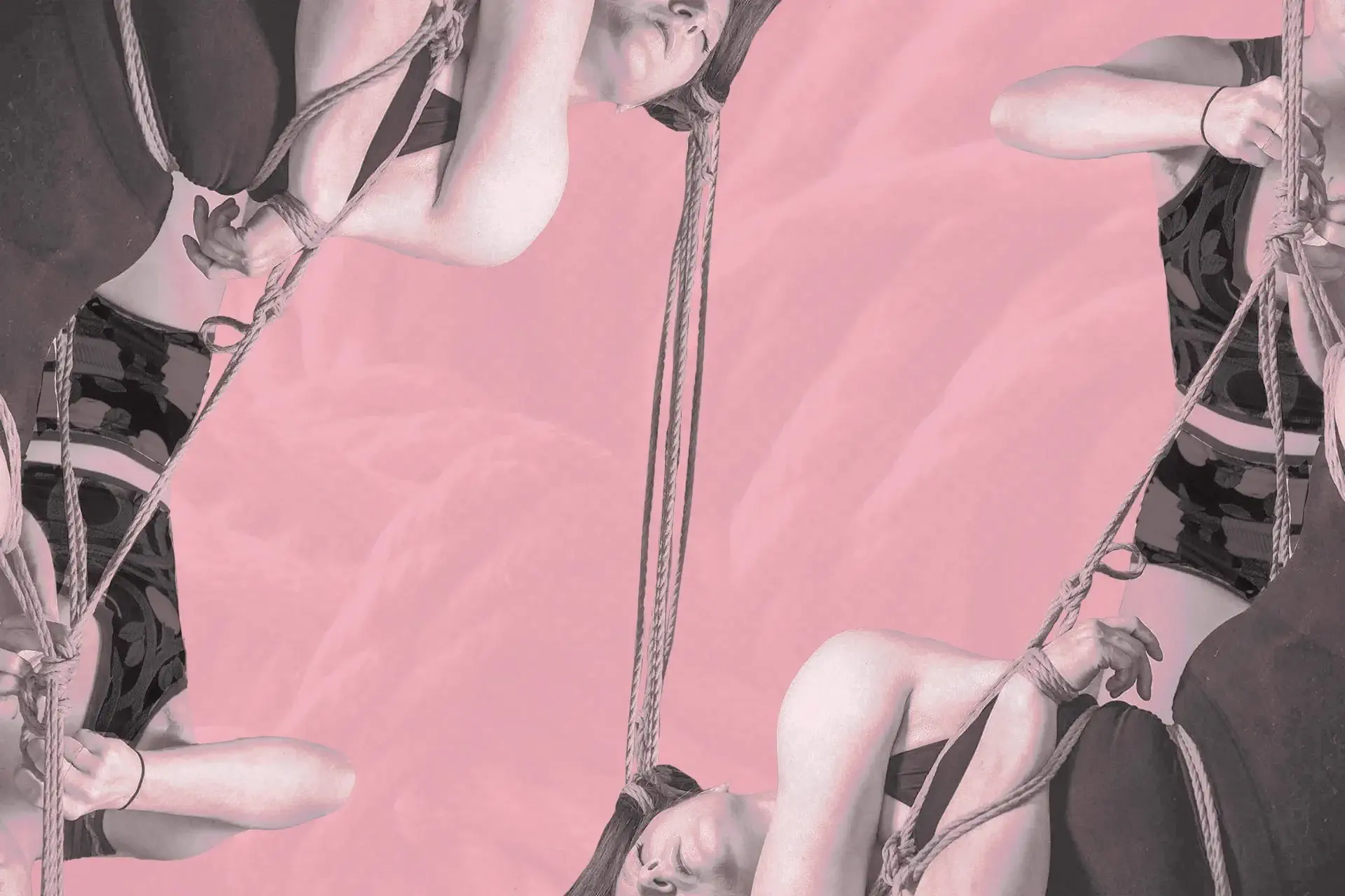 A rigger and bottom are tying a shibari suspension with hair rope on a pink background.