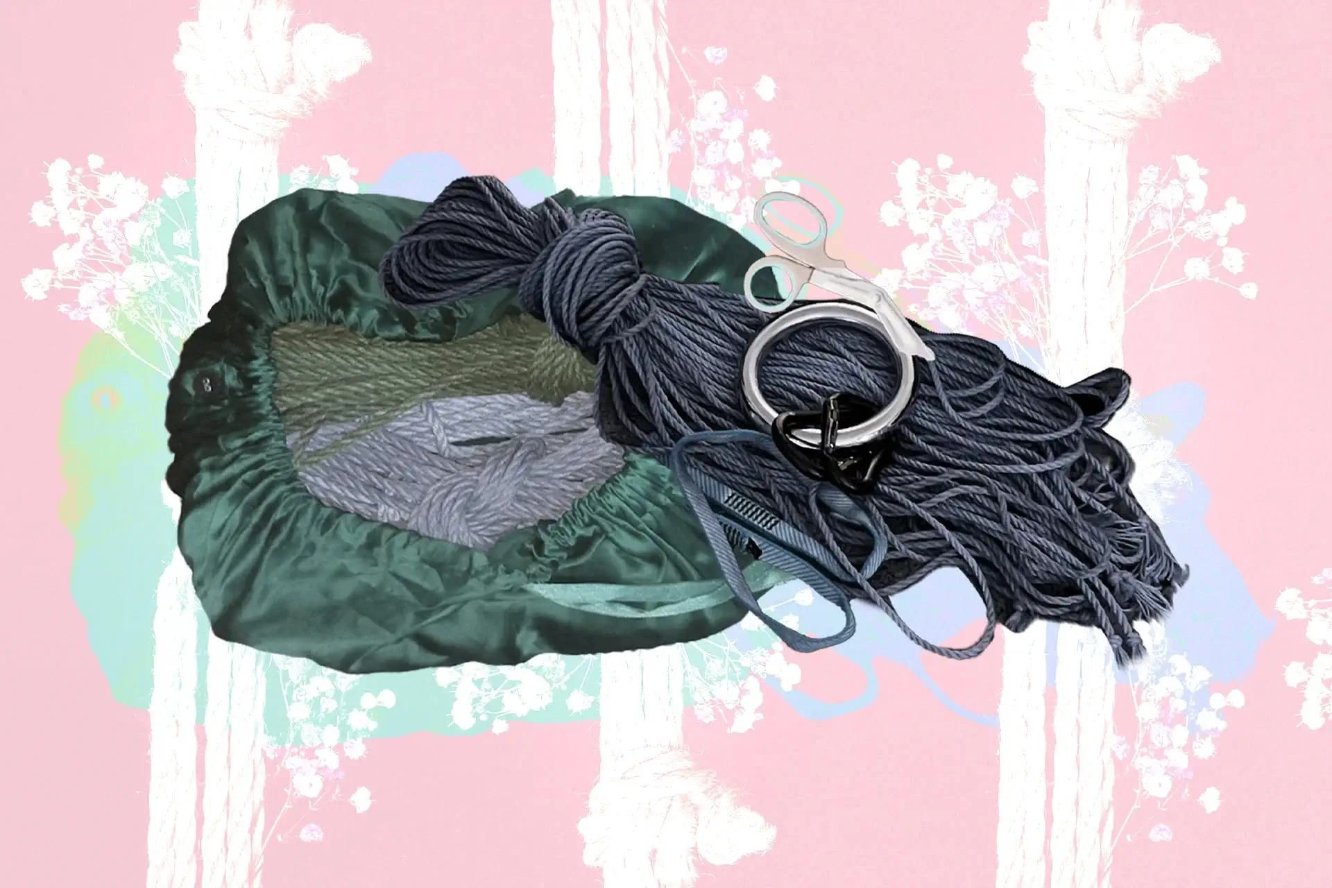 A bag with Shibari rope bundles, safety shears, and a suspension ring against a pink background.
