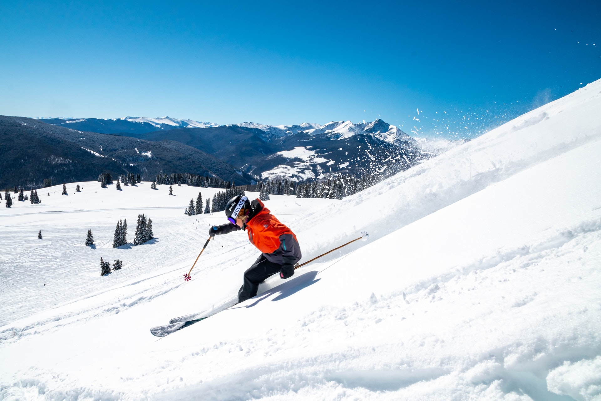 A person dressed in ski gear skiing down a snow covered slope.