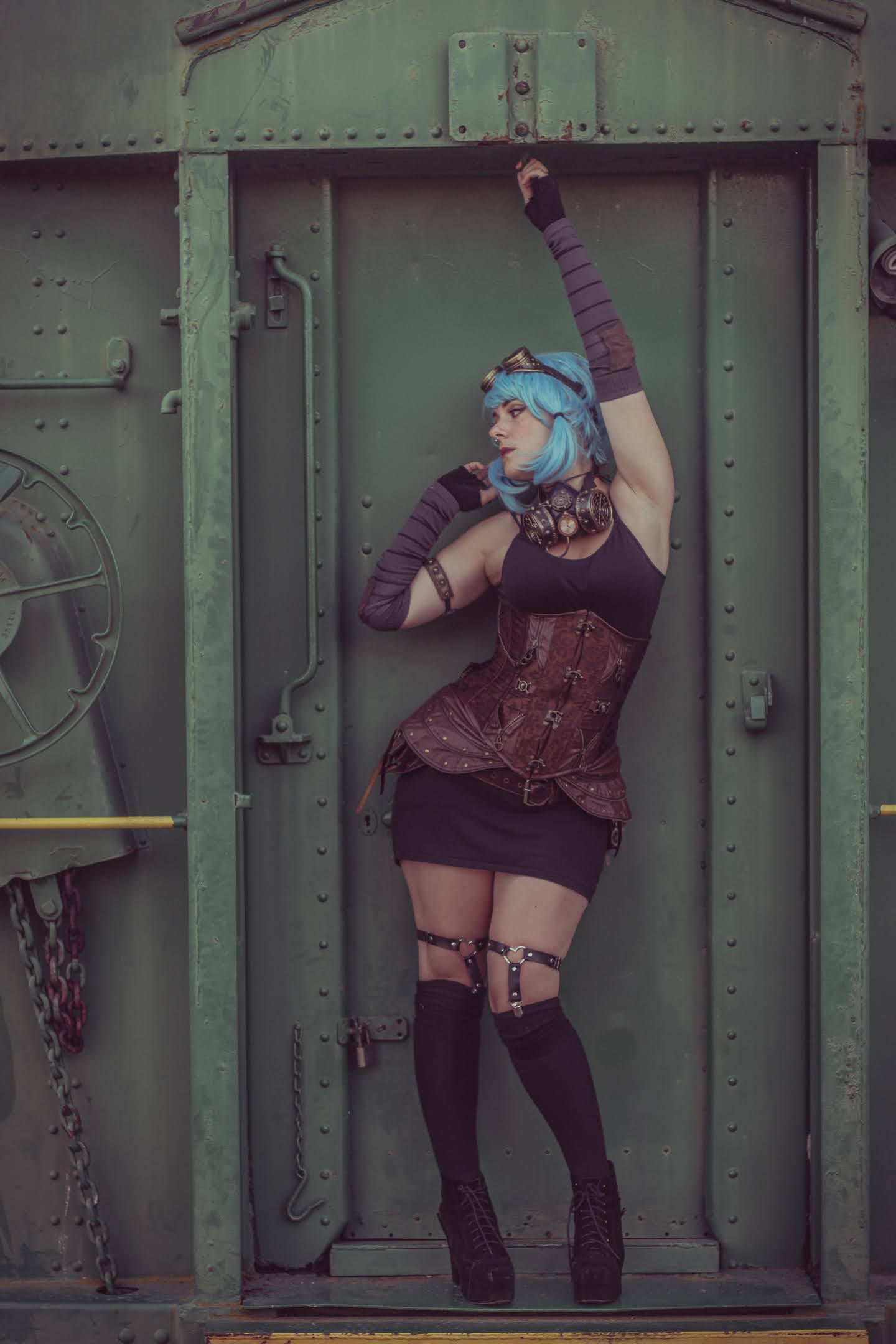 A steampunk woman posed in front of a train door