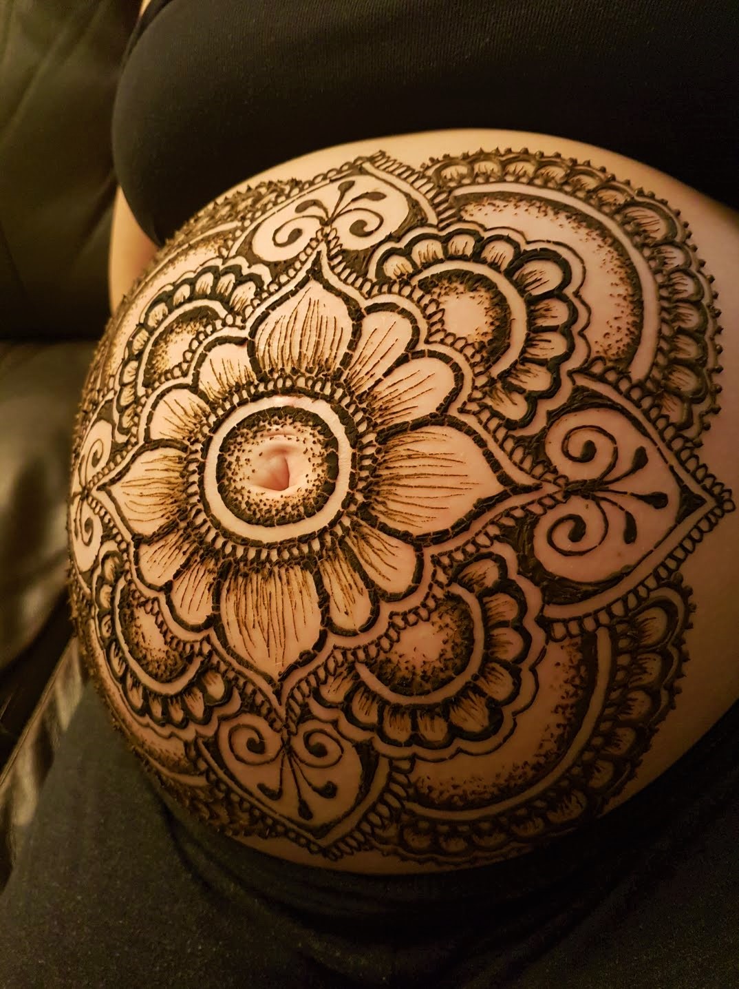 A pregnant belly covered in beautiful henna designs 
