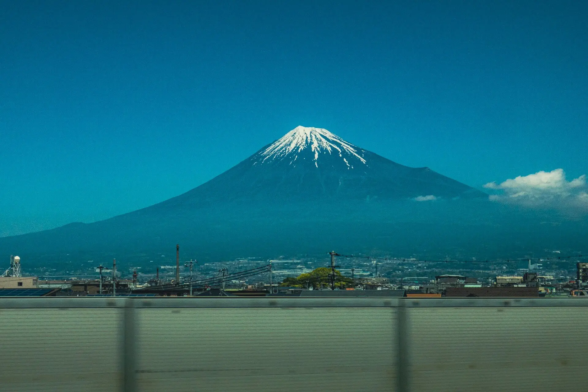 Mount Fuji with its signature snow crown on a cloudless blue sky