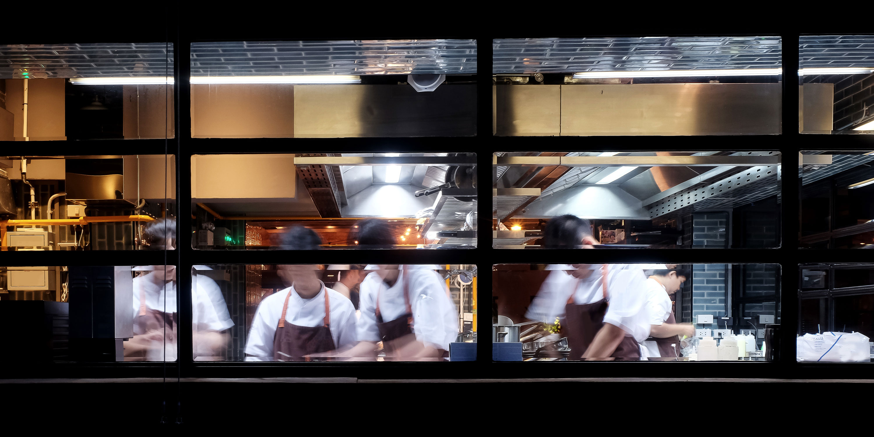 Foto de pessoas em uma cozinha com janelas de vidro