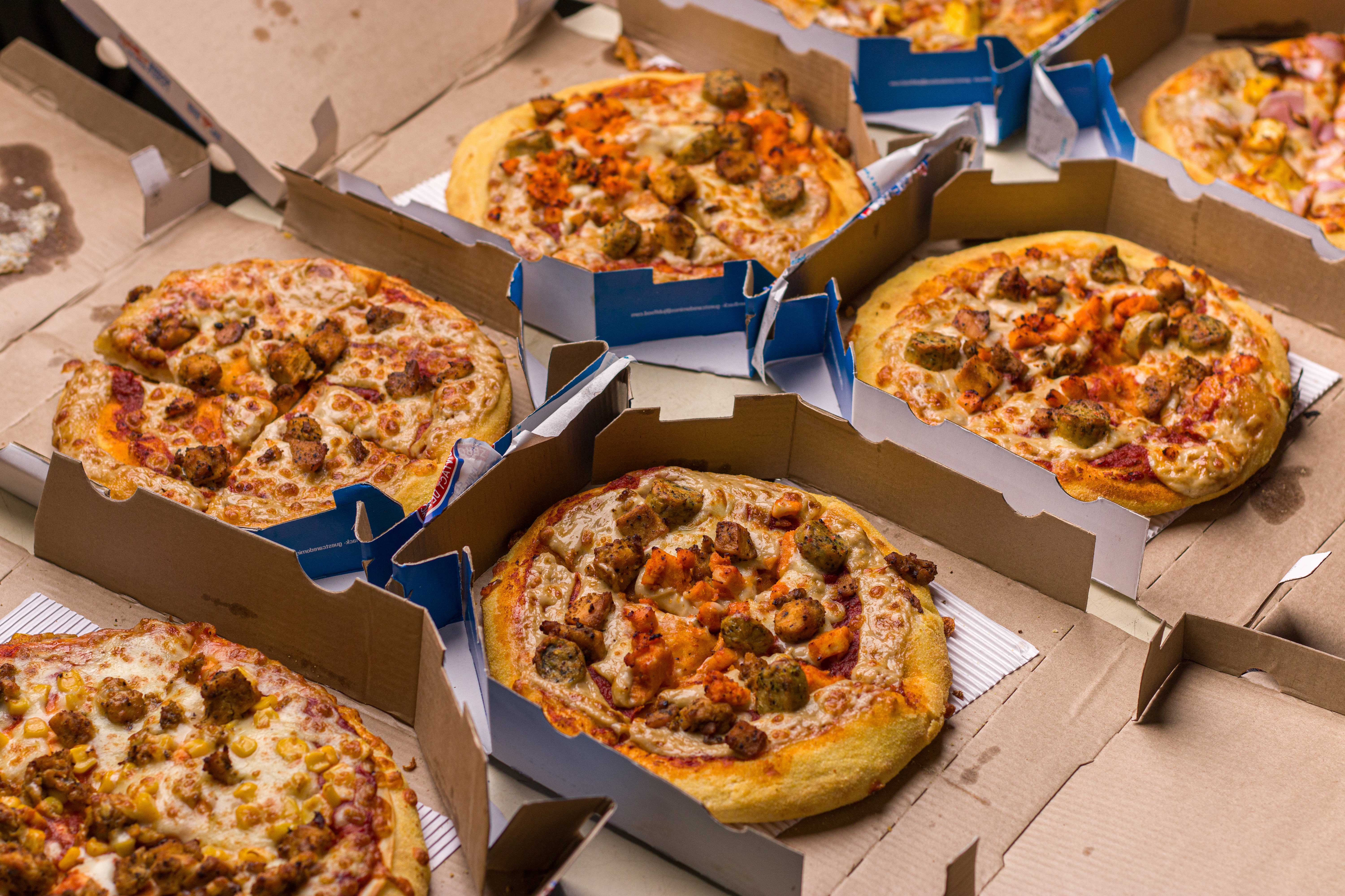Foto de muitas pizzas sendo entregues por delivery