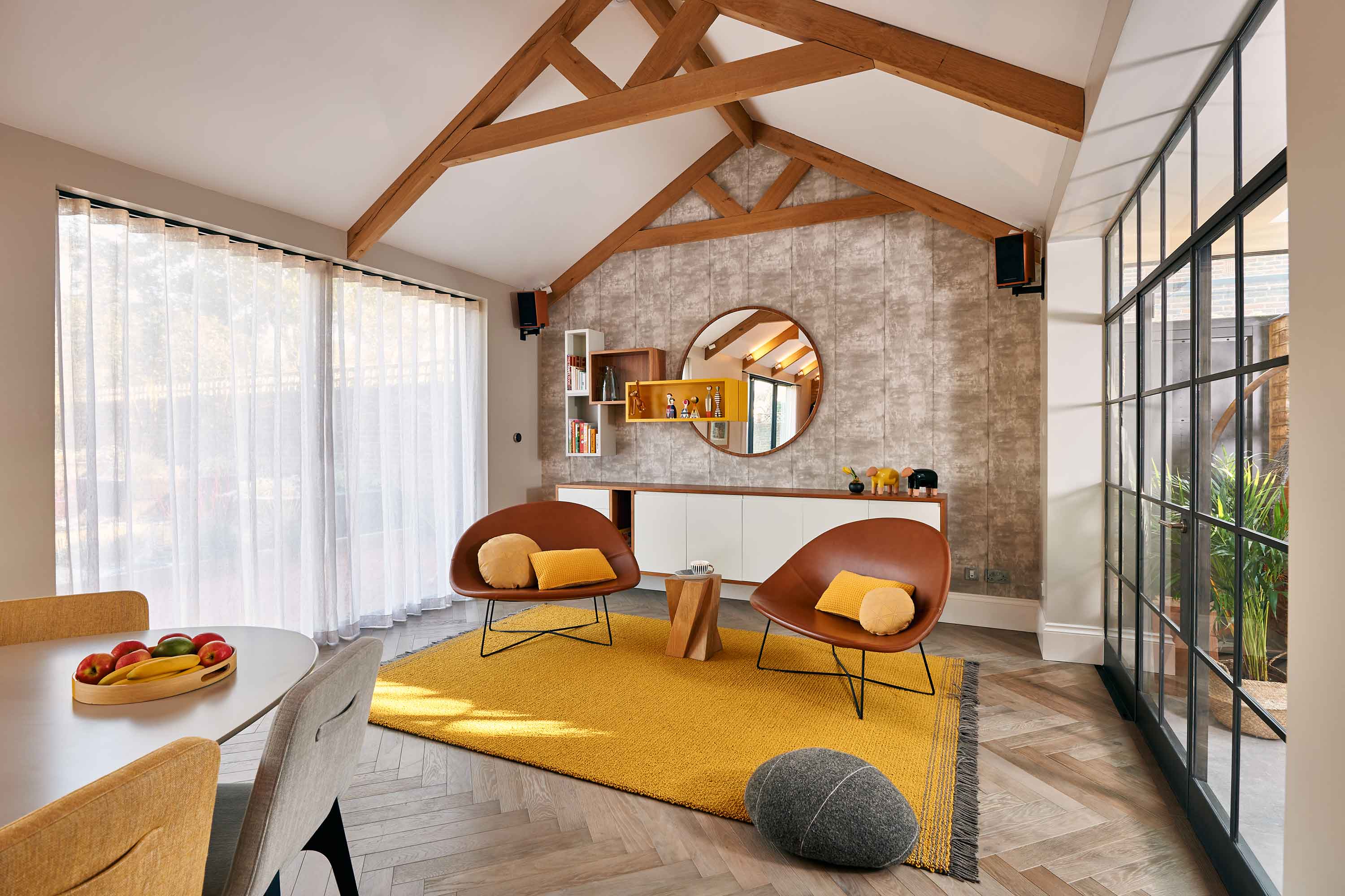 bright living area with exposed beams and leather chairs