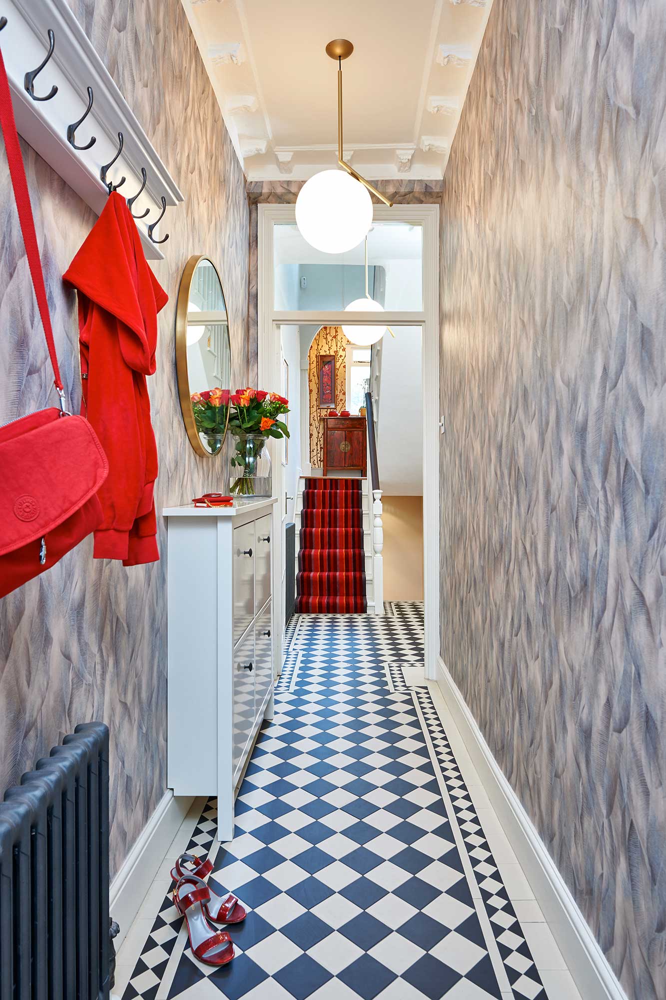 hallway with feature wallpaper and monochrome floor tiles