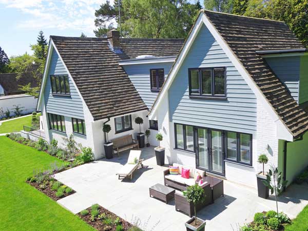 Light blue and white house with green lawn.
