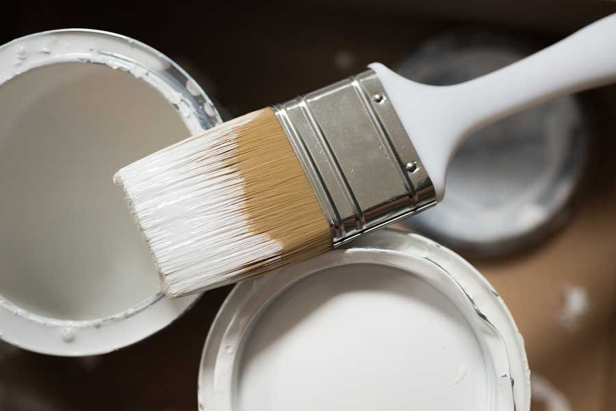 White paint brush and white paint bucket.