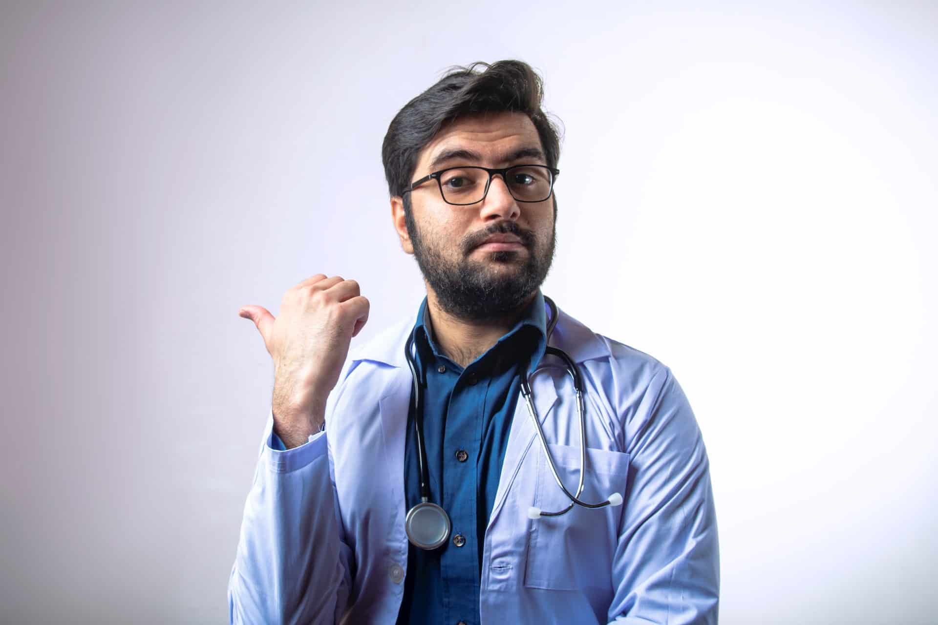A doctor pointing behind himself.