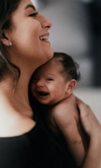 A mother and her newborn baby. Her child insurance starts at birth.