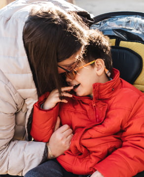A mother cuddles her special-needs son. Child insurance helps parents with childcare needs.