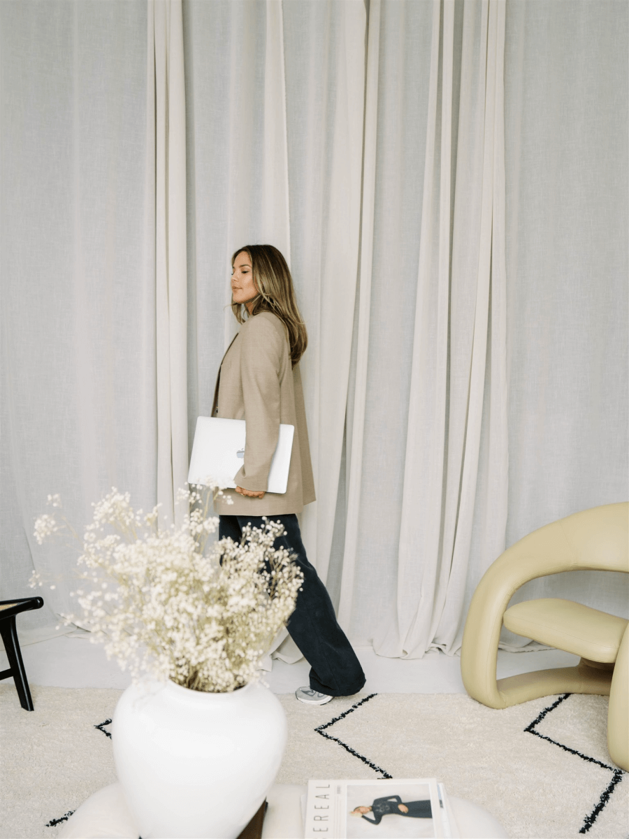 Lindsay Mariko walking through her design studio with a laptop in hand