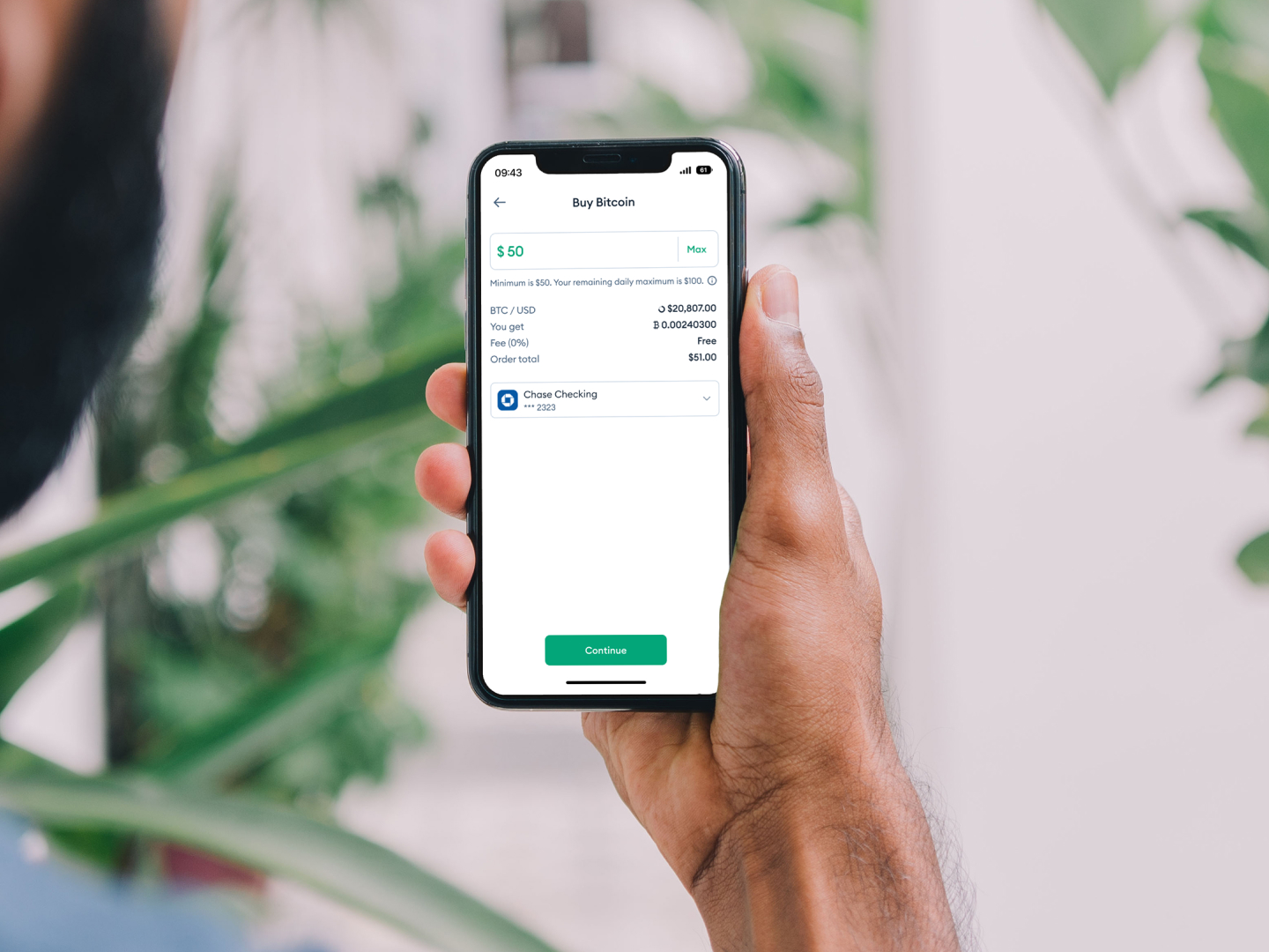 Buy Bitcoin screen on an phone held by a hand.