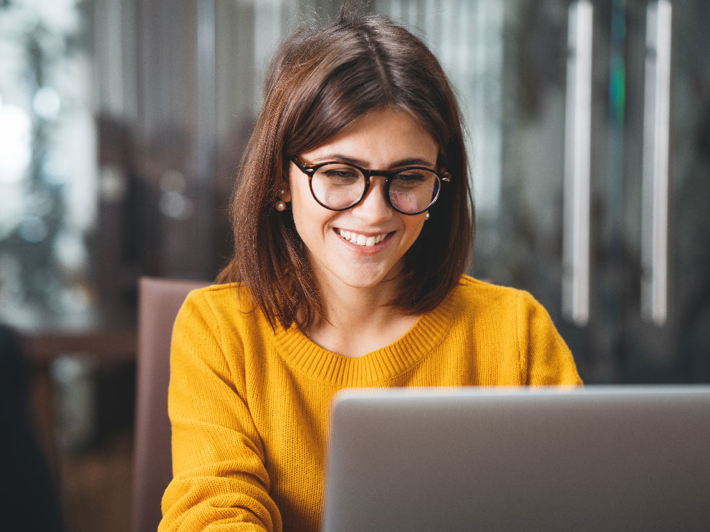 Woman looking at her Coinbits dashboard on her computer