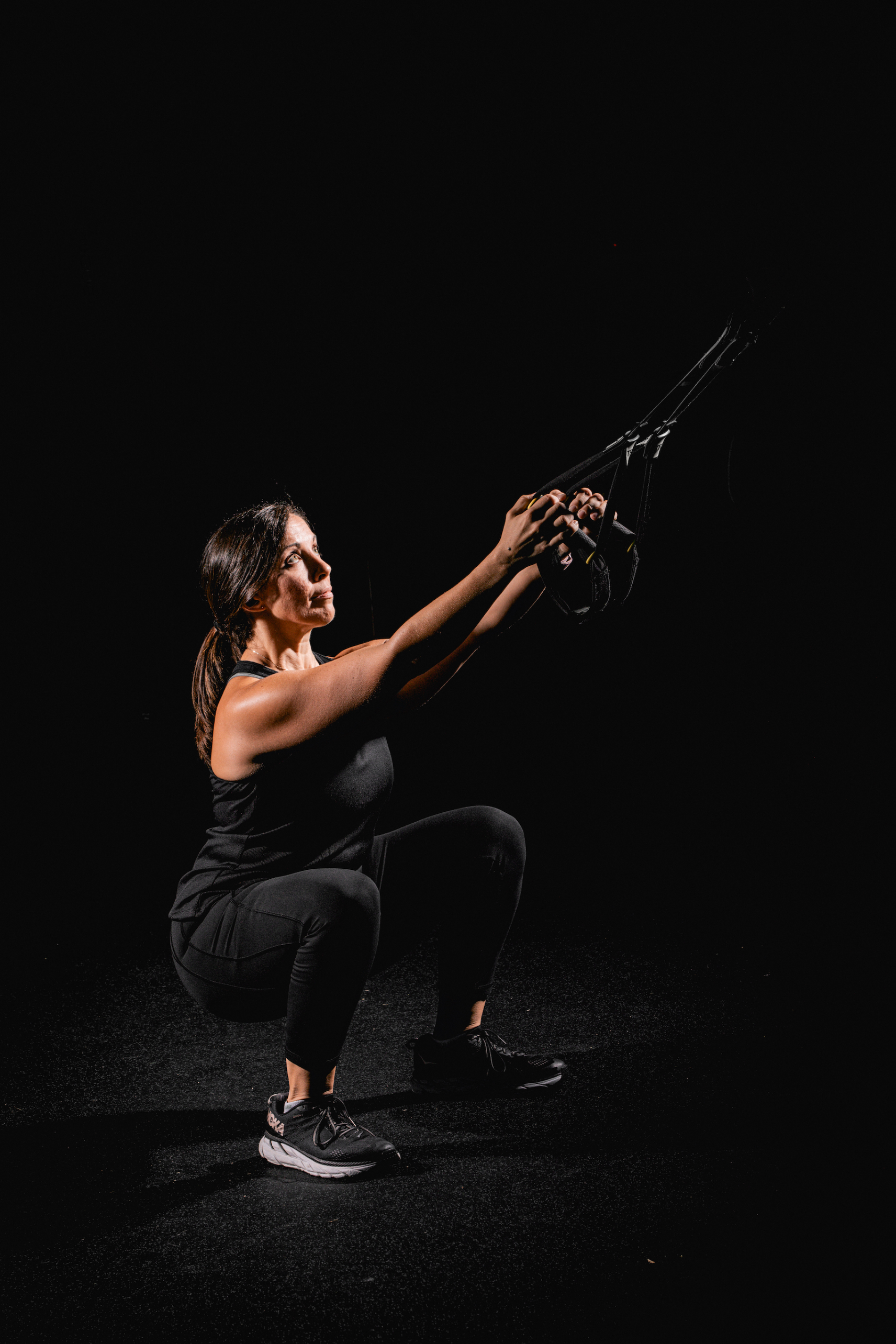 Woman doing a TRX band squat