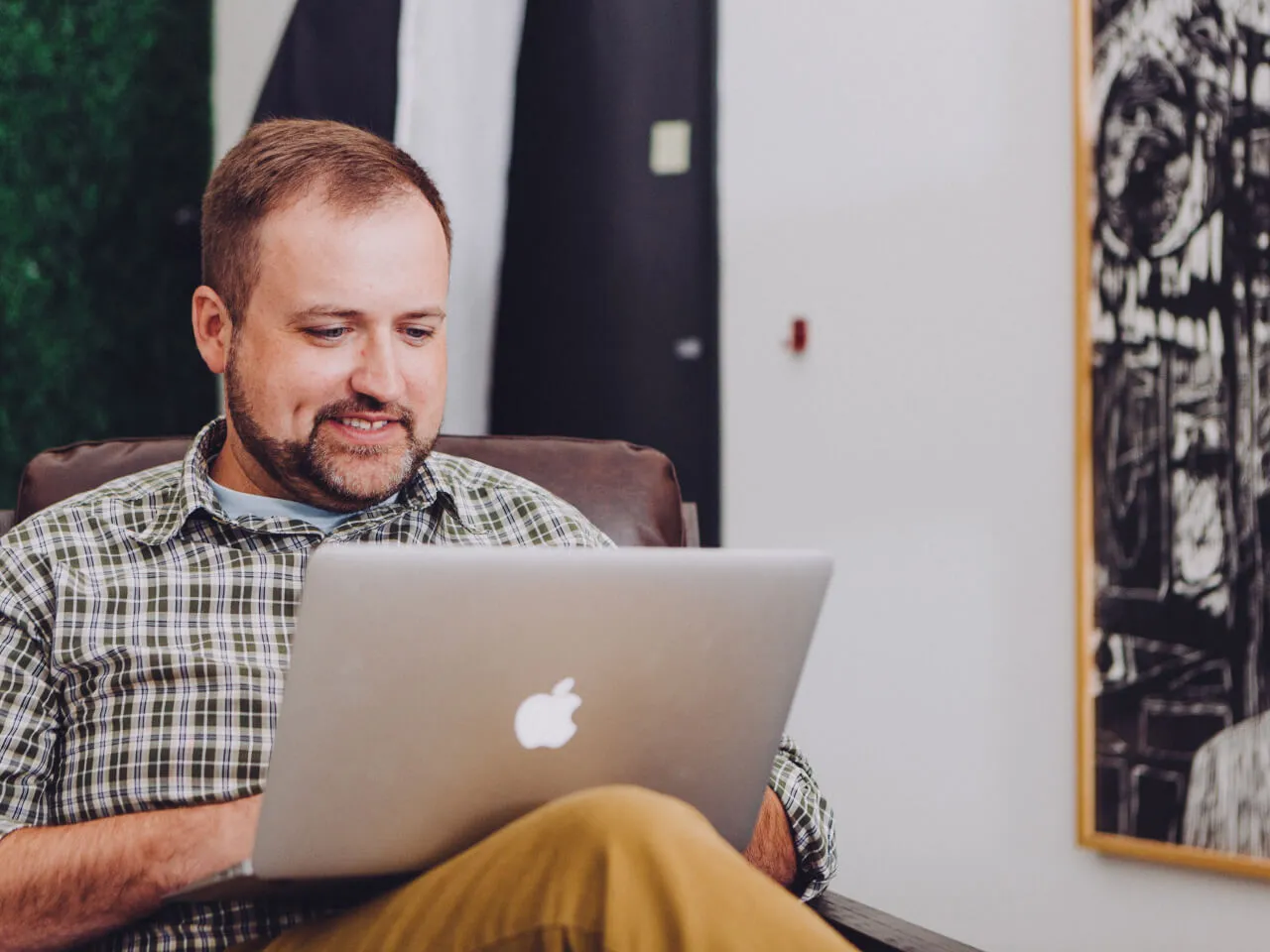 A man sitting in a chair on his laptop